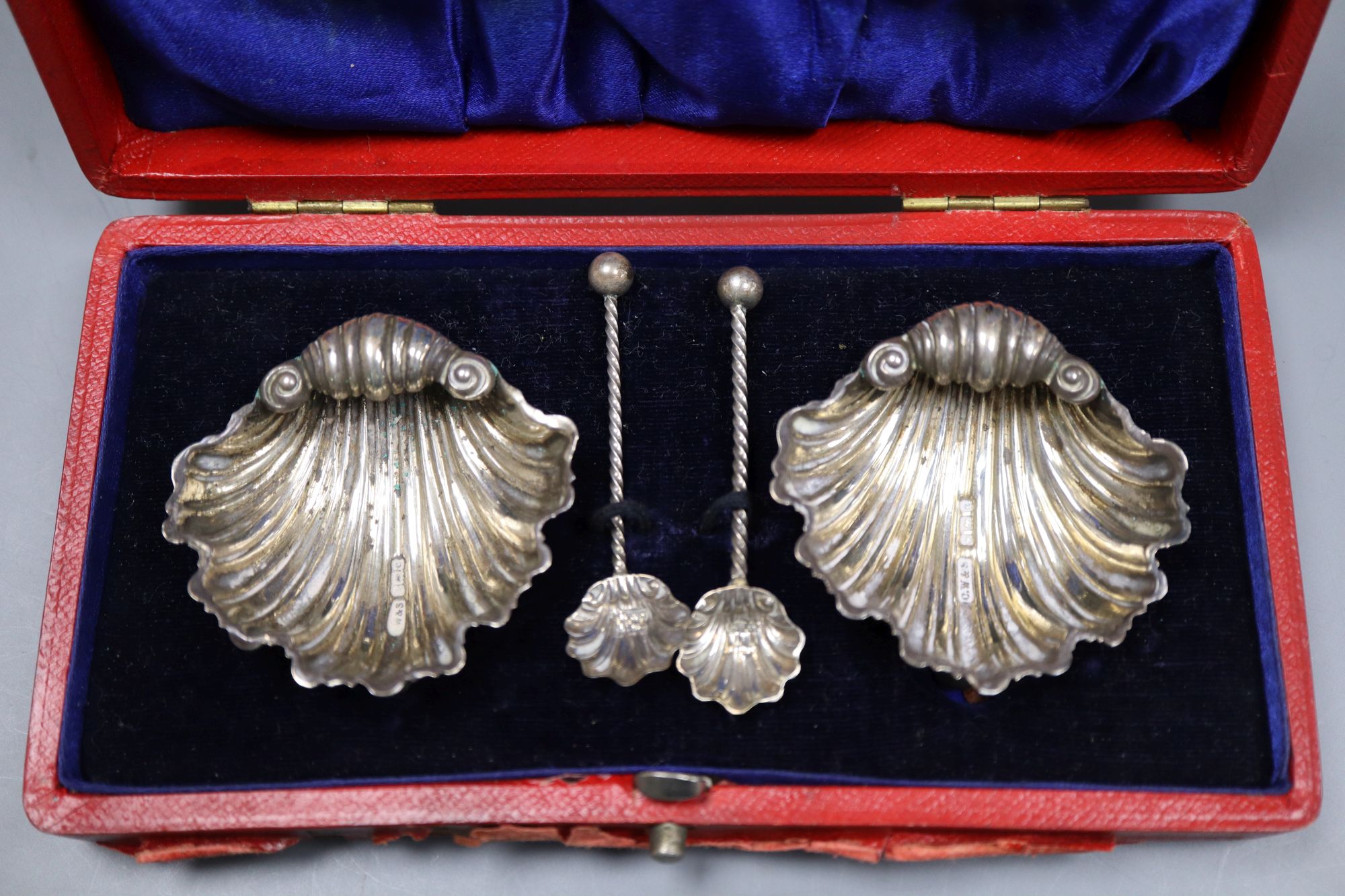 A pair of Edwardian silver shell salts and spoons and a similar twin compartment sovereign case, 61mm